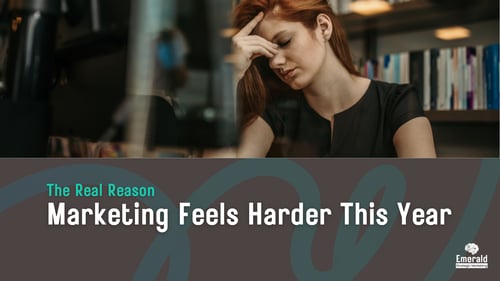 A marketing professional at their desk looking stressed. Text: The Real Reason Marketing Feels Harder This Year