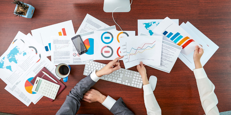 Business leaders reviewing a pile of marketing and sales metrics.