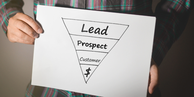 A person holding a paper that shows a sales/marketing pipeline.