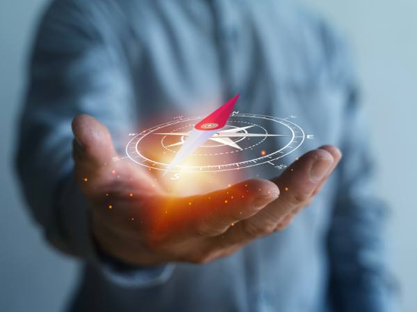 A person holding a digital compass in their hand.