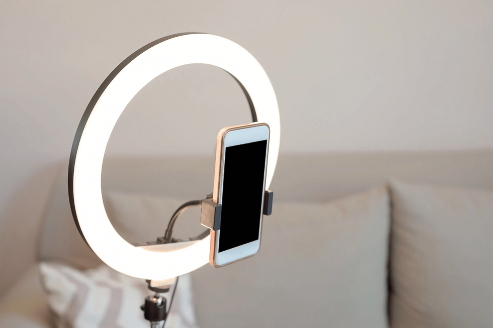 A ring light holding a cellphone for a person about to do a Q & A Live Session on social media.