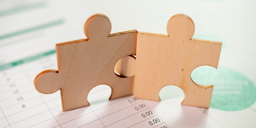 Two puzzle pieces sitting on a paper with numbers on it.