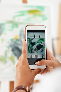 A person taking a photo of a piece of art at a store