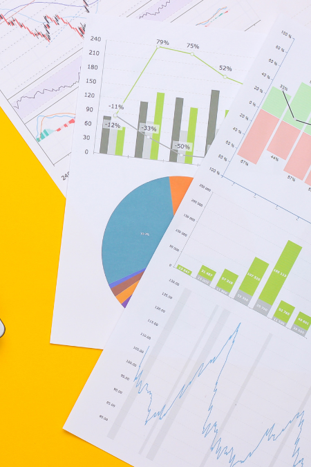 Printed charts and graphs on a bright yellow table.