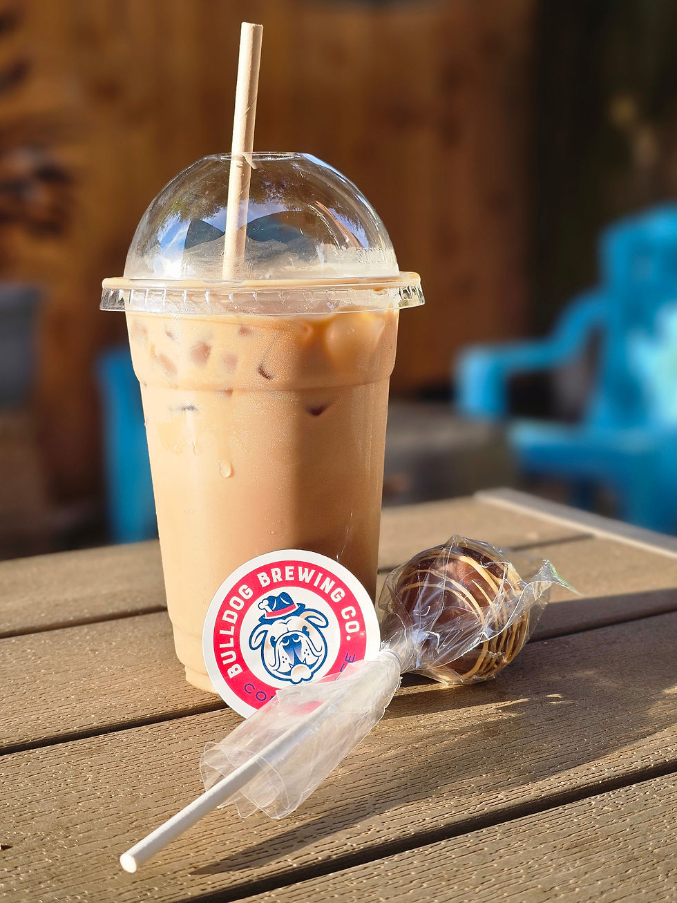 An ice coffee, a cake pop, and a company logo sticker