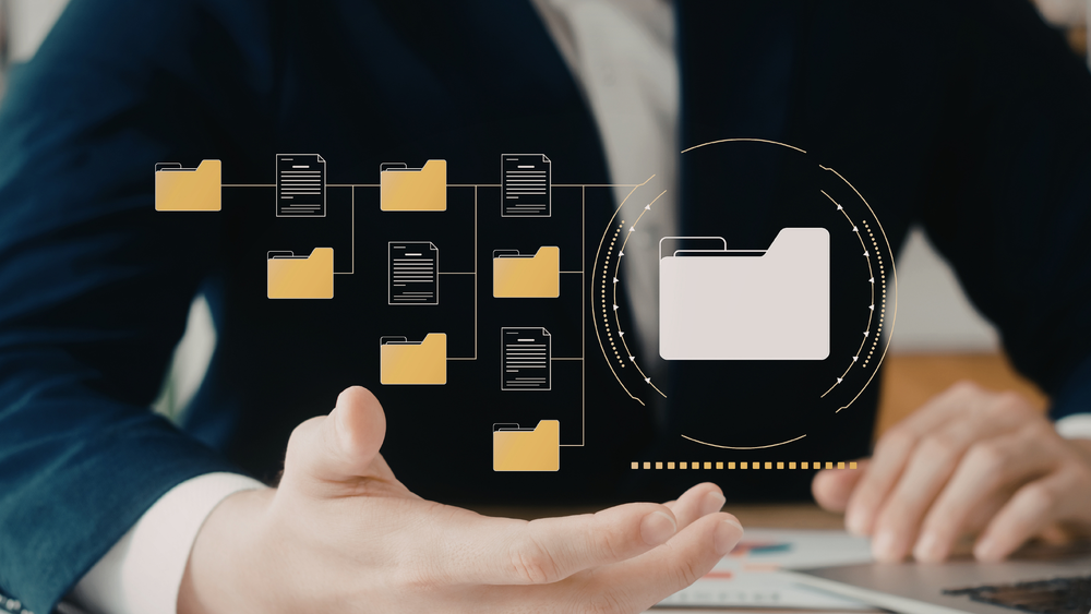 An image of a person with their hand extended. On their hand are floating graphics of digital folders and documents.